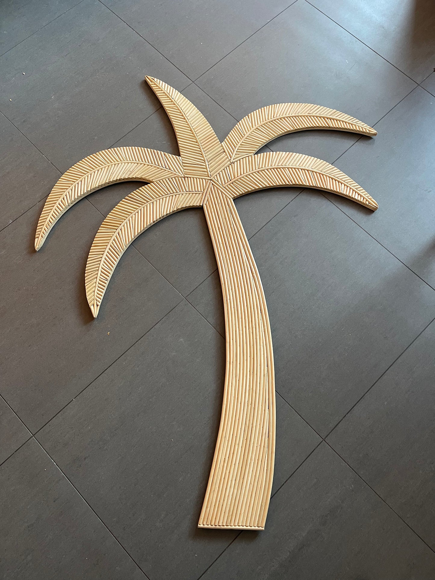 Op de afbeelding staat een prachtige houten palmboom wanddecoratie, die een tropisch en organisch element toevoegt aan elke ruimte.