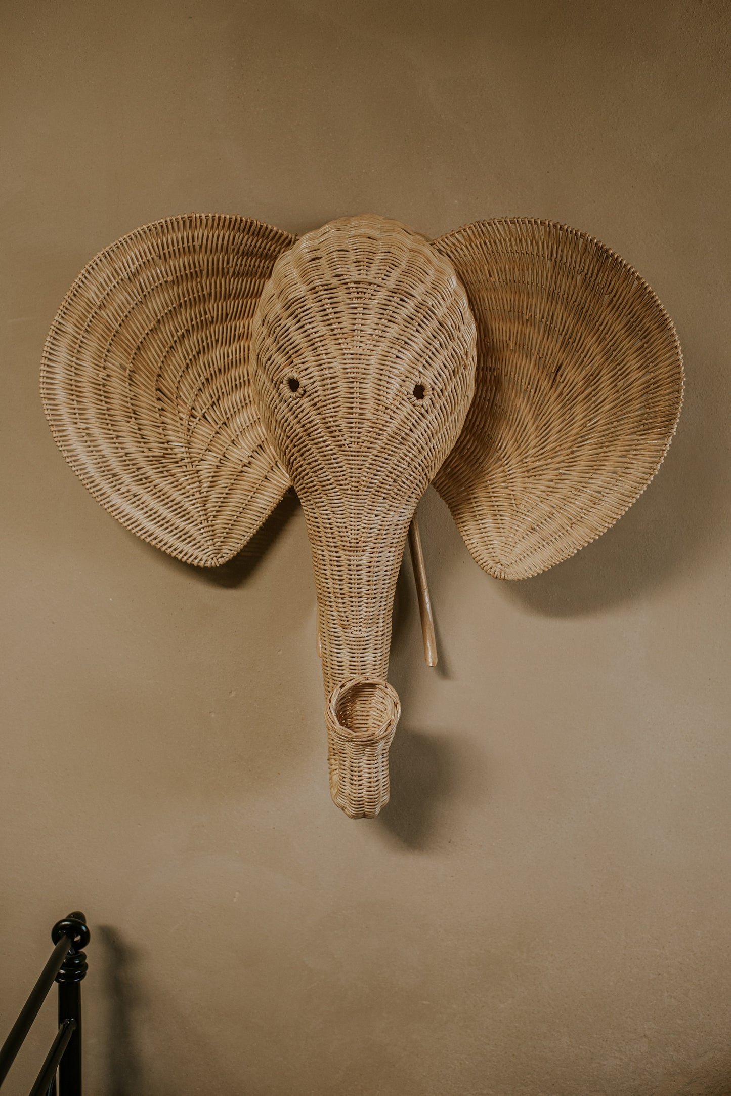 Op de afbeelding staat een prachtige rotan olifantenkop wanddecoratie, die een exotische en organische sfeer toevoegt aan elke muur.