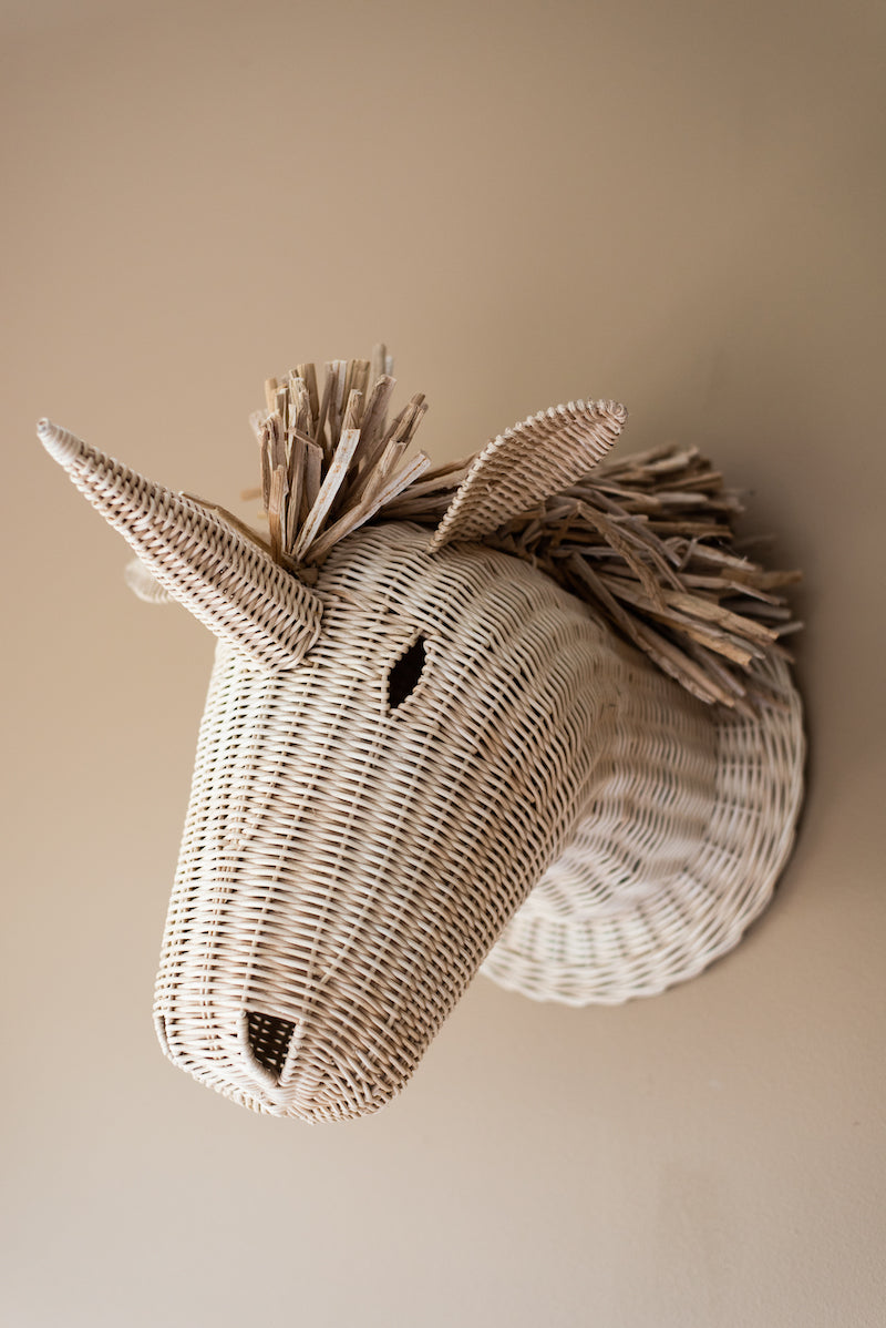 Rotan kop van een eenhoorn voor aan de wand. Het gedetailleerde ontwerp maakt dit stuk uniek en opvallend, terwijl de duurzame rotan constructie ervoor zorgt dat het een langdurige aanwinst is voor elk interieur. Dit betoverende kunstwerk voegt een vleugje fantasie toe aan elke kamer en is een geweldige decoratie voor de slaapkamer, kinderkamer of woonkamer. Perfect voor iedereen die houdt van eenhoorns.