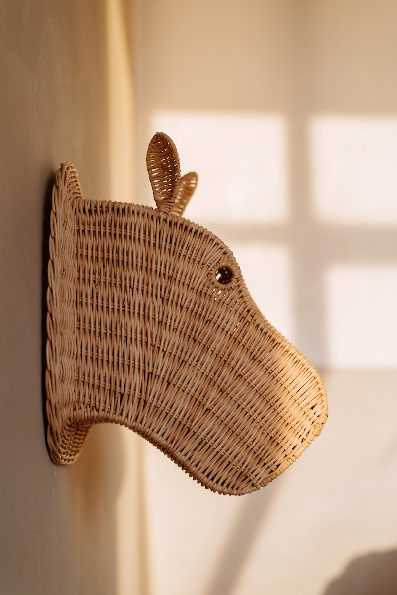 Op de afbeelding staat een charmant rotan nijlpaardenhoofd wanddecoratie, die een betoverende en exotische uitstraling biedt aan de kinderkamer. Handgemaakt van duurzaam materiaal, is deze decoratie een stijlvolle en duurzame toevoeging aan het interieur.