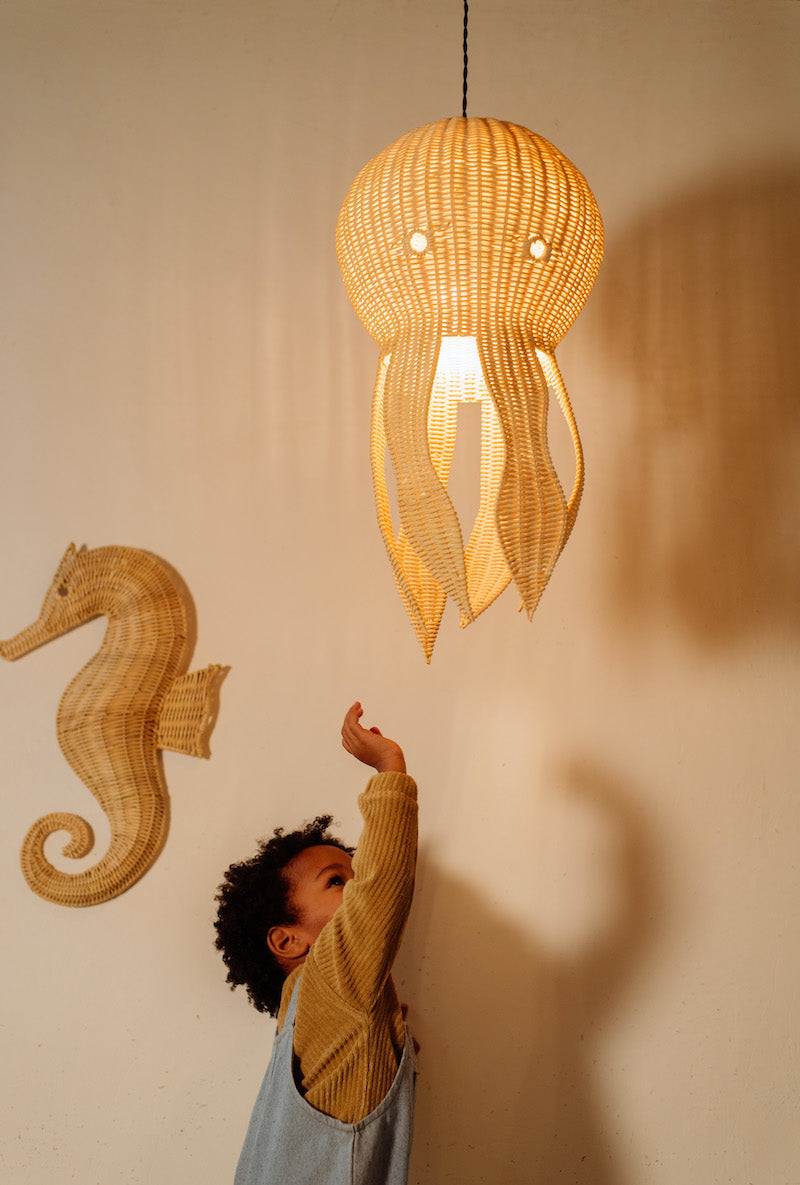 Op de afbeelding is een schattige rotan octopus lamp te zien, perfect voor het toevoegen van een speels en organisch element aan de kinderkamer. Handgemaakt van duurzaam materiaal, biedt deze lamp een zachte en warme gloed die zorgt voor een gezellige sfeer. Het unieke ontwerp van de octopus voegt een charmante en betoverende uitstraling toe aan elke kinderkamer. Deze rotan octopus lamp is een leuke en praktische toevoeging aan elke ruimte.